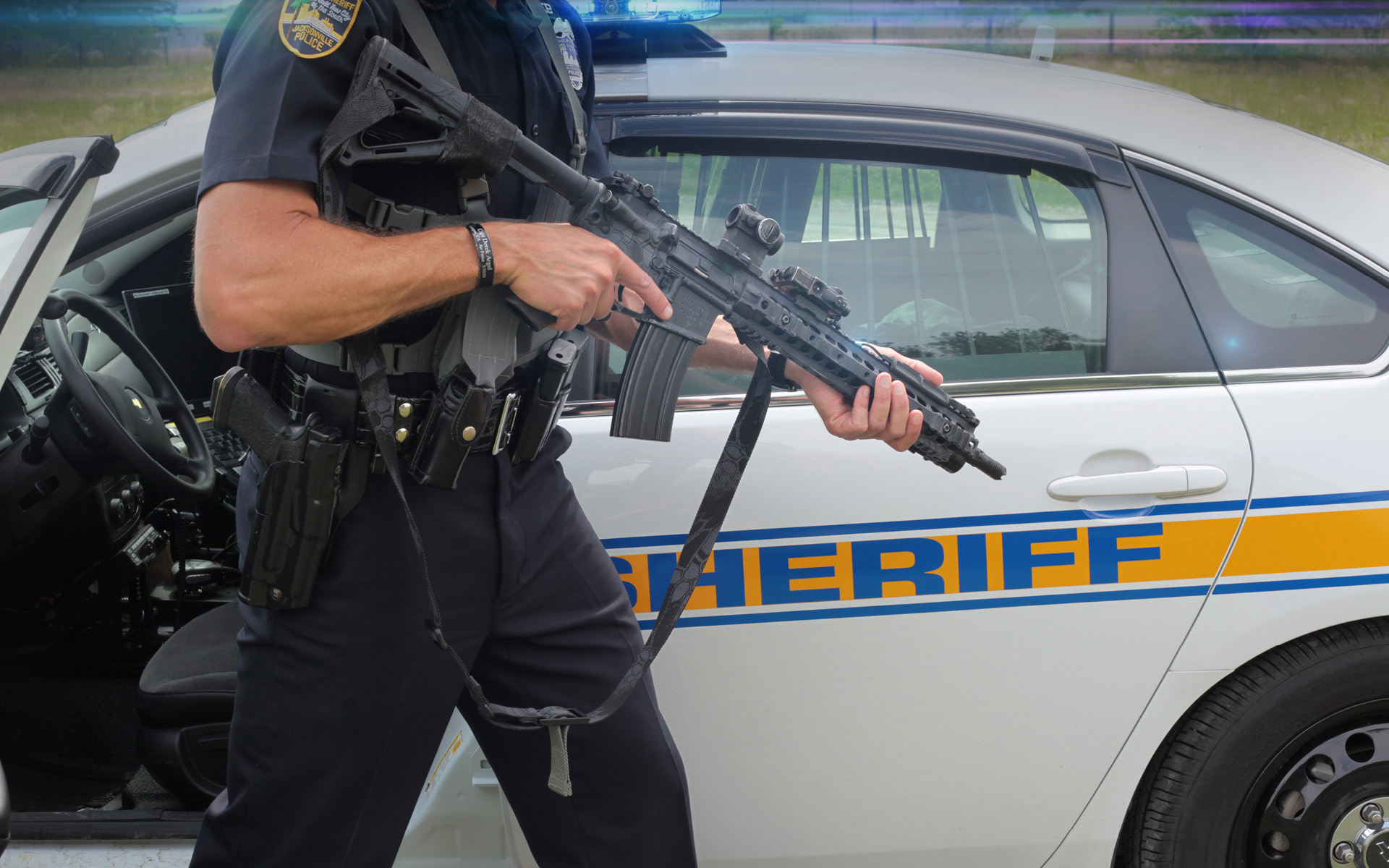Police officer exiting patrol car with push button vickers push button sling 